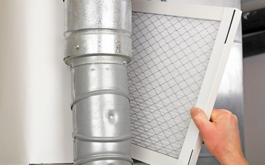 A hand in the process of changing an HVAC Filter. Changing filters should be top of the list for regular HVAC maintenance.